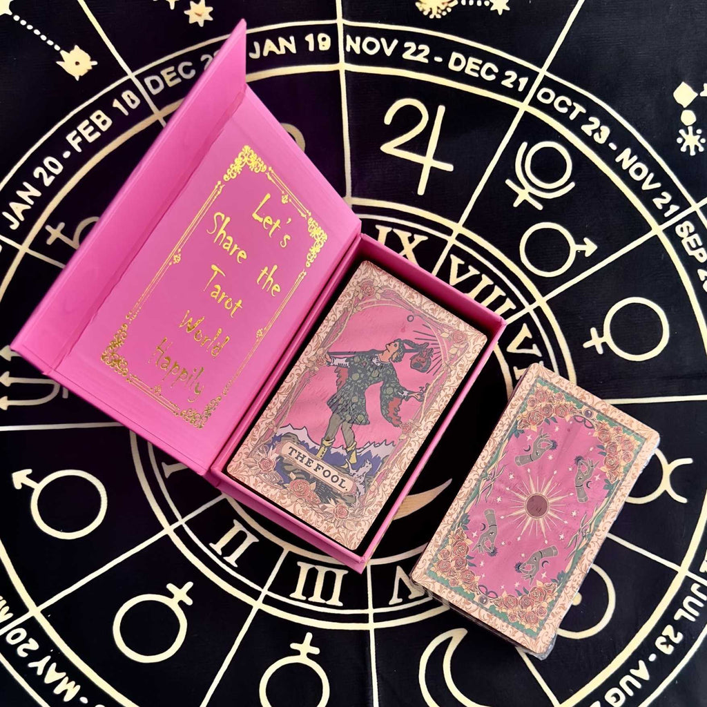 Pink foil tarot card deck with 'Let's Share the Tarot World' text on a black astrological circle background.