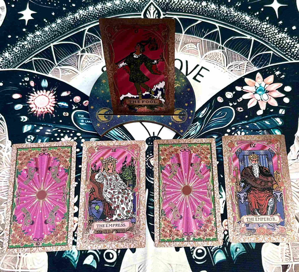 Collection of gold foil tarot cards with decorative background featuring celestial elements.