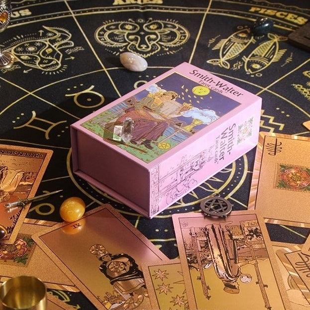 Pink tarot card box on a tarot card table with Rose Gold Foil tarot cards and other paraphernalia.