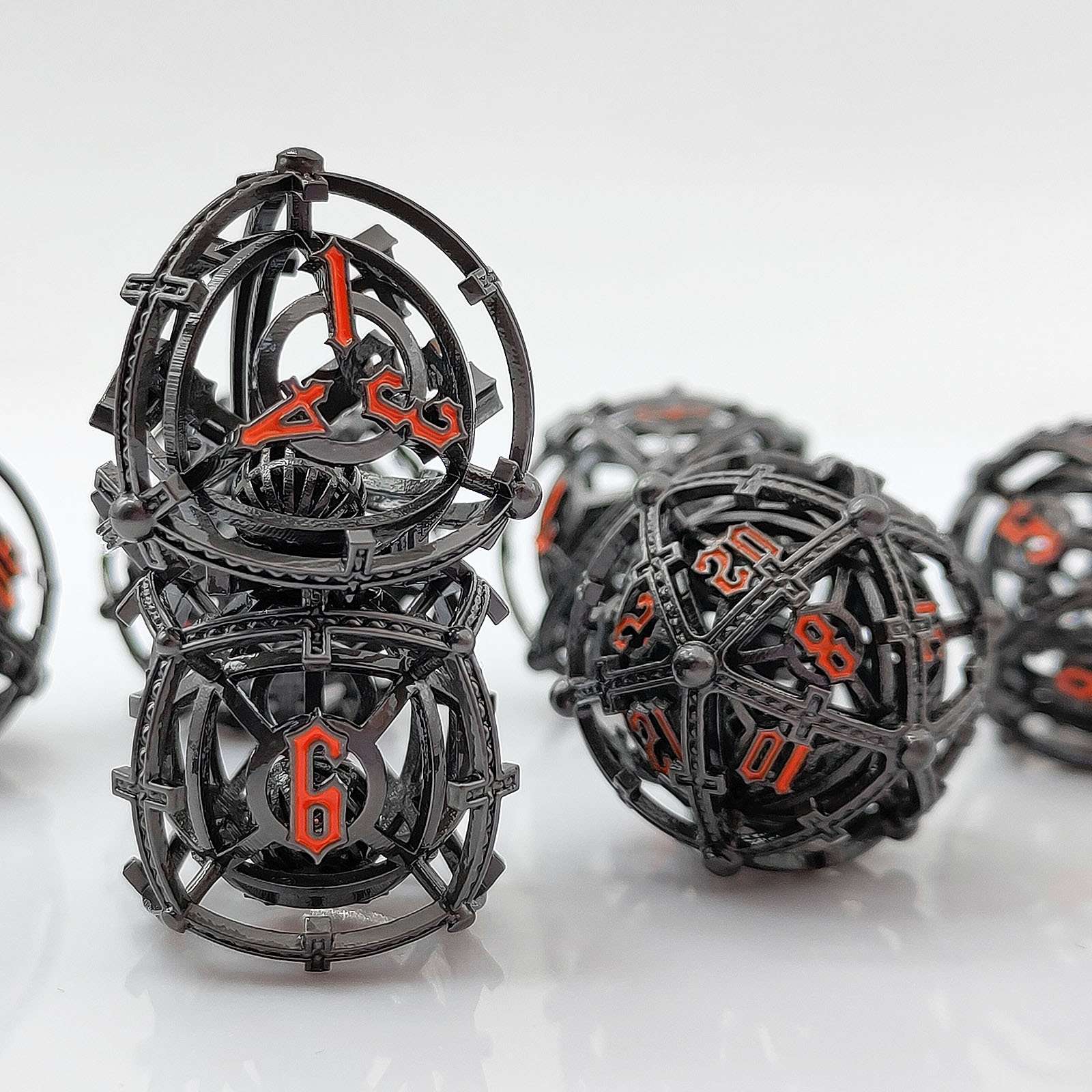 Black and orange Hollow Metal Orb Chime DND dice set on a white background