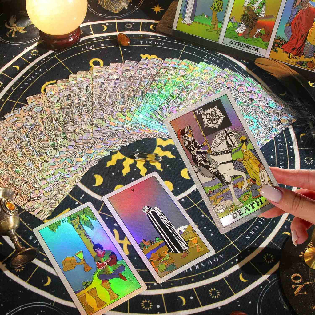 Fanned Premium silver Glitter Tarot cards on a tarot table with a hand holding a card.