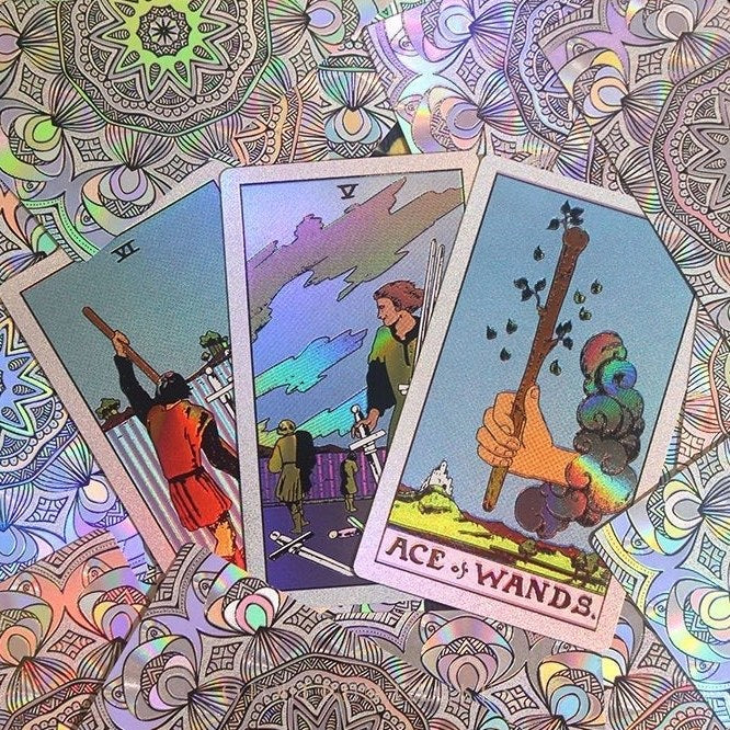 Three Premium silver Glitter Tarot cards tarot cards with colorful designs on a patterned background