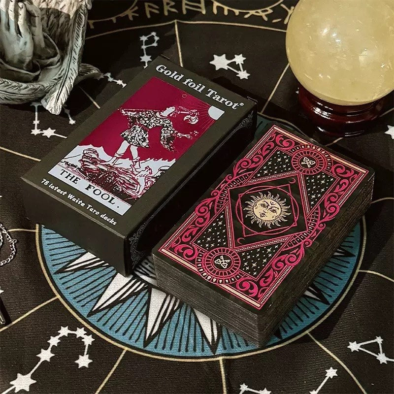 Solis & Luna Gold foil tarot cards with decorative box on a mystical tablecloth.