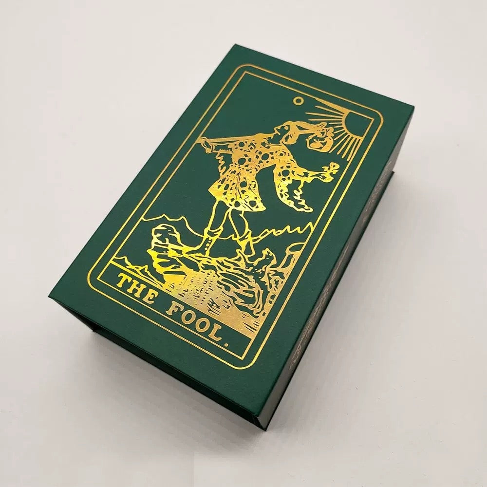 Green tarot card box with gold 'The Fool' design on a white background