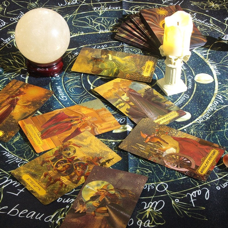 Collection of tarot cards on a mystical tablecloth with a crystal ball and candles.